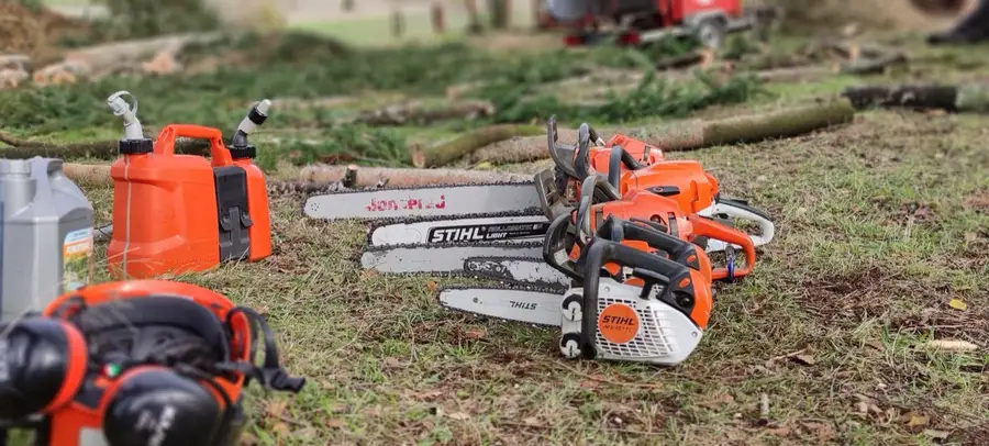 Tronçonneuses et guides alignés au sol, prêts avant le chantier
