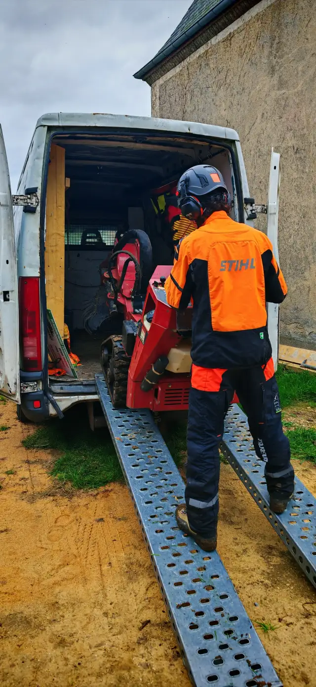 Souche de cerisier au milieu d'un jardin clos de centre-ville, sans accès engin : la STX 26 (moins de 90 cm de large, chenilles) passe et rogne — intervention insérée dans une journée 100 % rognage, frais de déplacement divisés