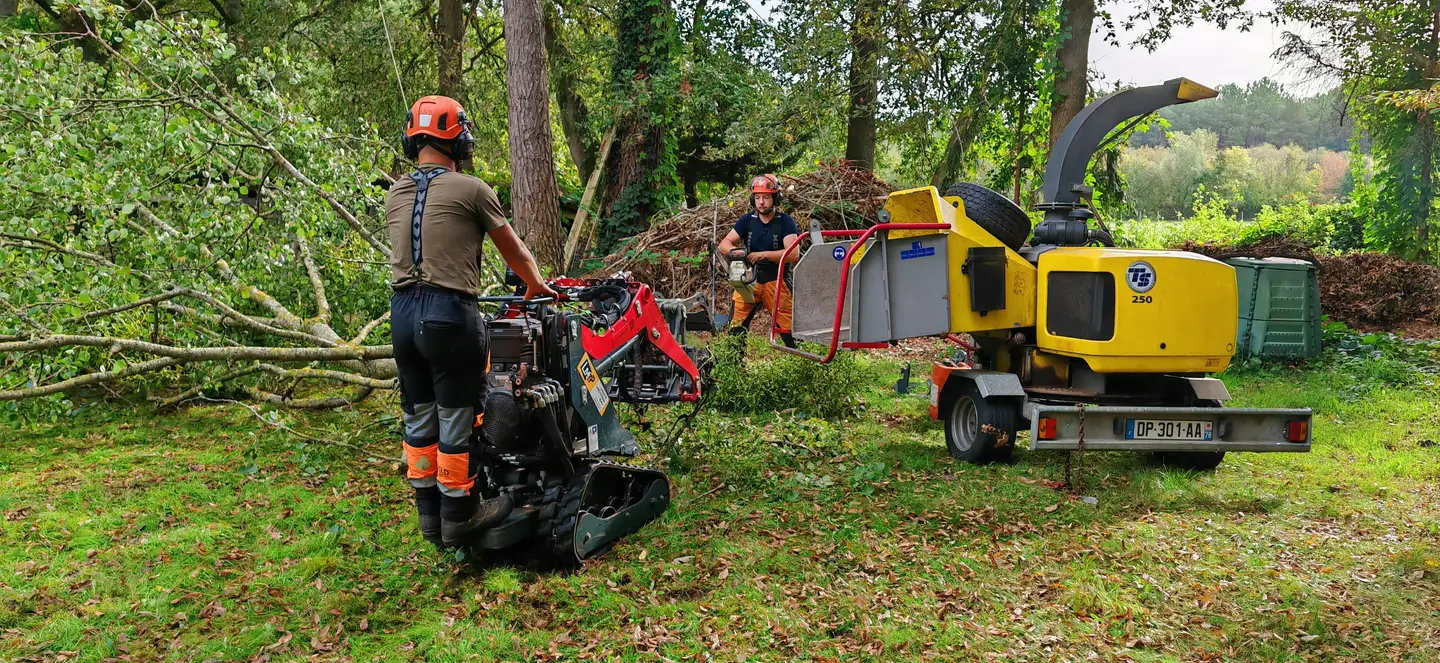 L'équipe Allô Jonathan en plein chantier : un opérateur au porte-outils sur chenilles, un second au broyeur, branches et broyat sur une prairie sarthoise