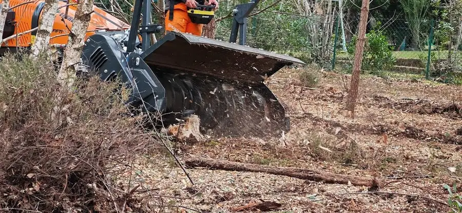 Tête de broyage en action dans la végétation, copeaux projetés