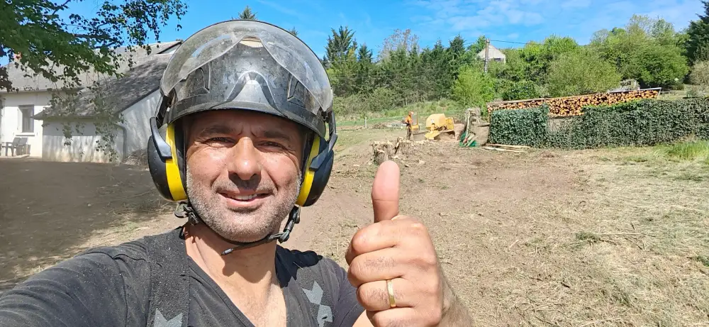 Jonathan sur le chantier, la rogneuse au travail derrière